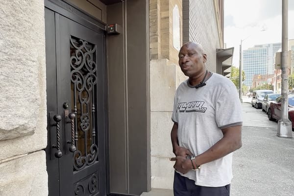 A man standing near an ornate entrance door