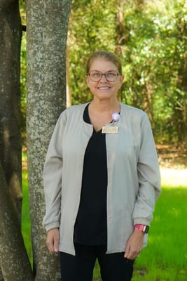 Staff member standing outdoors by a tree