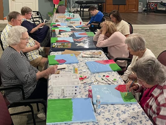 Residents engaged in a painting activity at a common area.