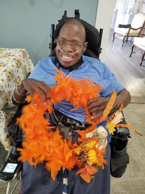 Resident joyfully creating a colorful craft project