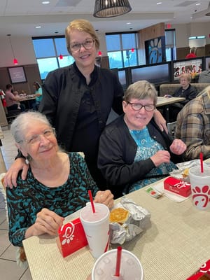 Residents enjoying a meal with staff at a dining area
