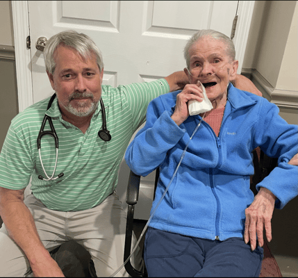 A staff member and resident smiling together indoors