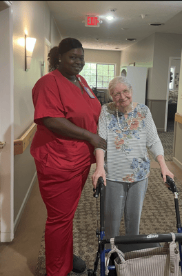 A caregiver assisting a resident in a hallway