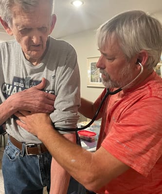 Staff assisting a resident with a health check