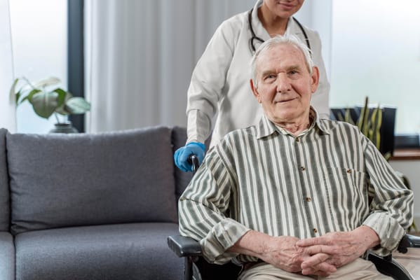 A caregiver assisting a senior resident in a cozy lounge