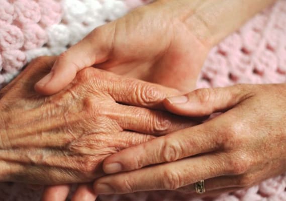 Close-up of two hands holding, symbolizing care and support