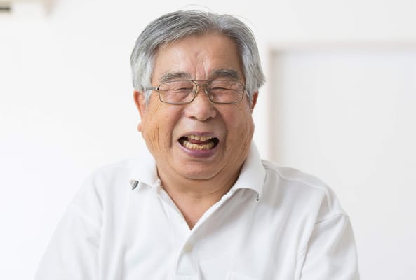 An elderly man smiling joyfully
