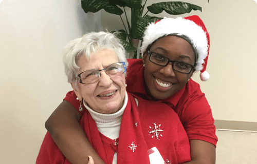 A resident and staff member celebrating the holidays together