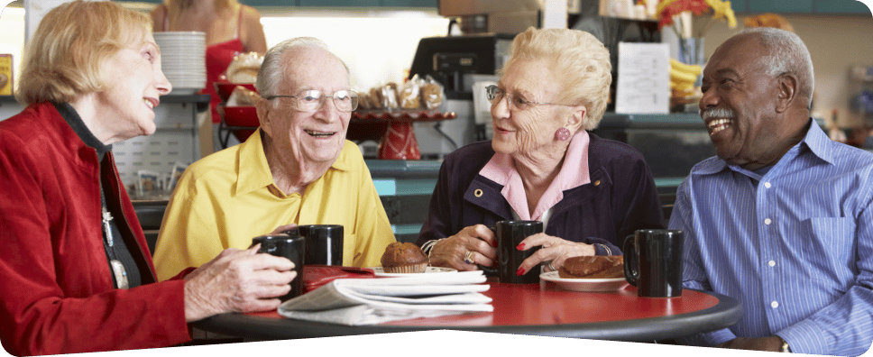 Four seniors enjoying coffee and conversation at a table