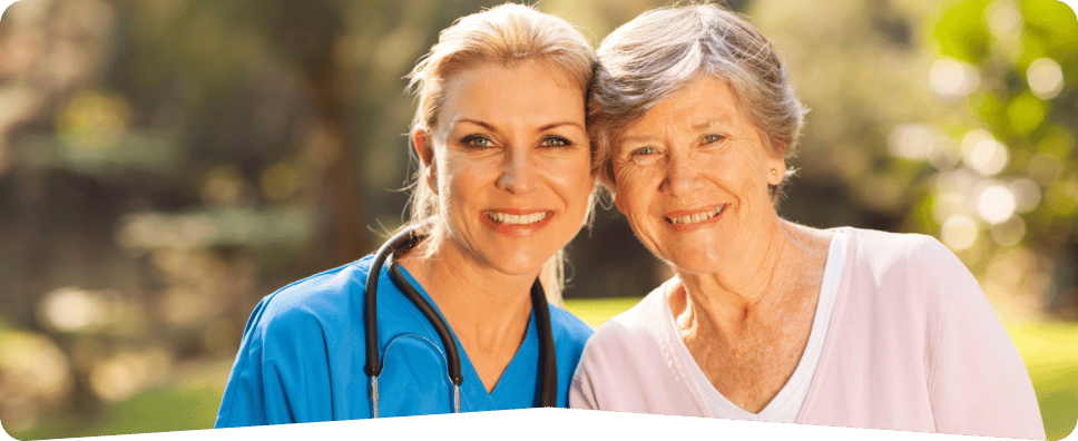 Healthcare worker smiling with a senior resident outdoors