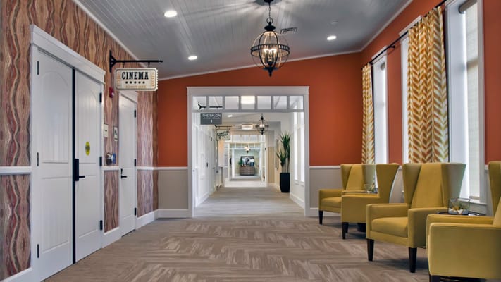 Interior hallway with yellow chairs and cinema sign