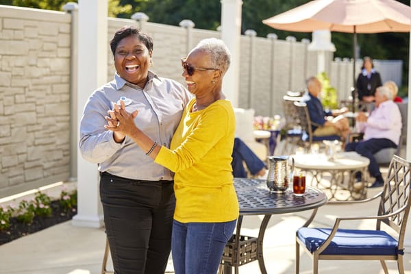 Residents dancing joyfully in an outdoor area.