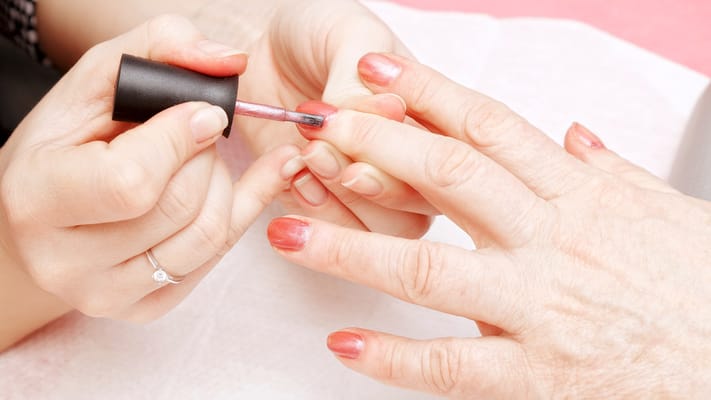 A resident getting a manicure from a staff member