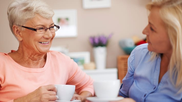 Two residents enjoying tea together in a cozy setting