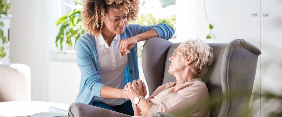 Staff member interacting with a resident in a cozy lounge