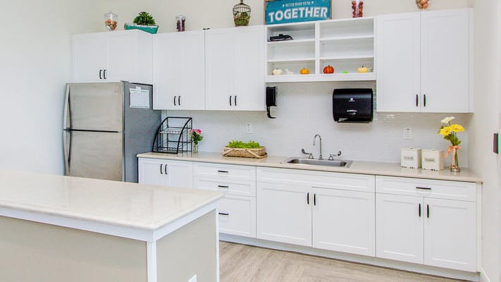 Modern kitchen area with white cabinetry and a sink