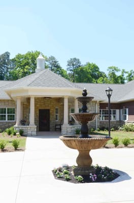 Exterior view of a senior living facility entrance with a fountain