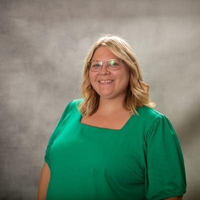 Portrait of a smiling staff member in green attire