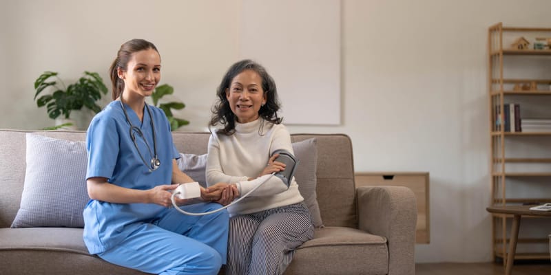 Nurse taking a resident's blood pressure in a cozy living area