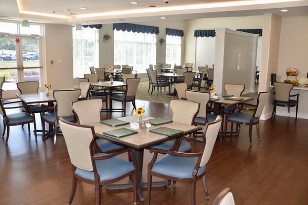 Bright dining room with tables and chairs set up