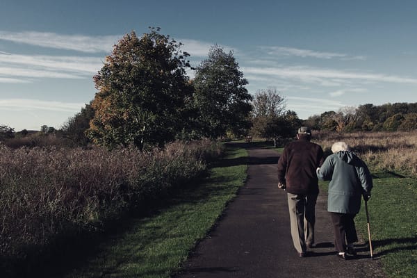 Elderly couple walking on a path in a natural setting