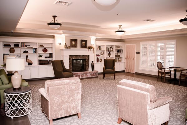 A cozy common area with comfortable seating and shelves.