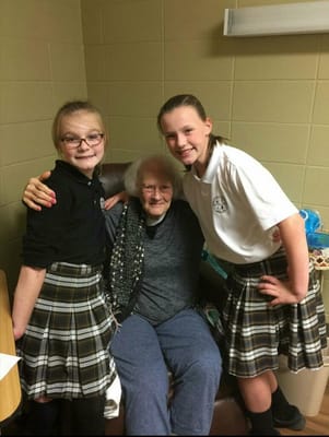 A resident with two young visitors in a cozy setting.