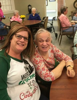 Resident and staff member smiling together in a common area