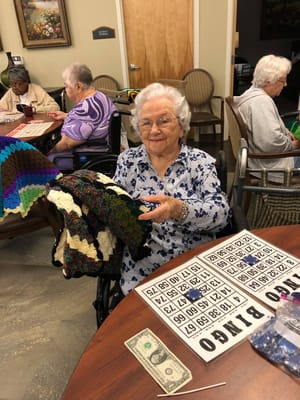 Resident enjoying bingo and knitting in an activity room