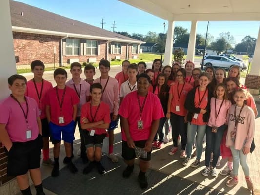 Group of teens wearing pink shirts at the facility entrance