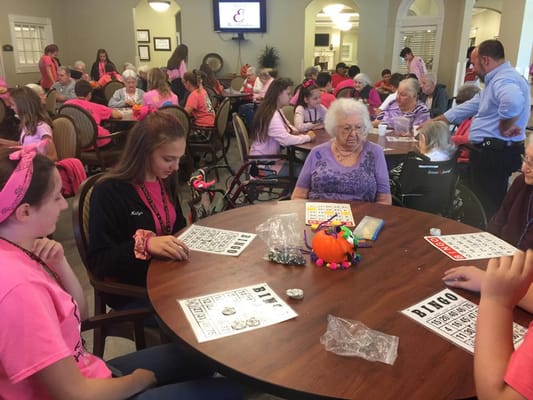 Residents and volunteers playing bingo in a common area