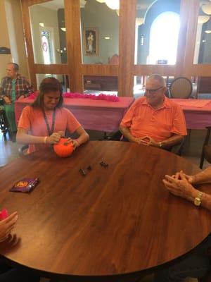 Residents engaging in a pumpkin decorating activity