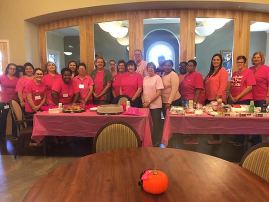 Staff and residents in pink shirts celebrating together