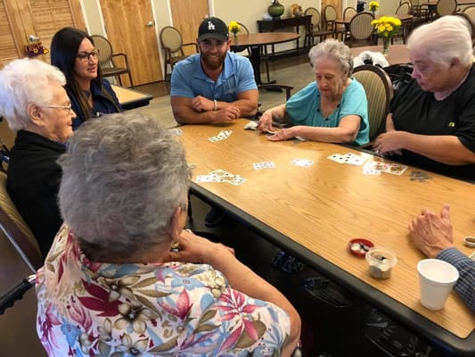Residents and staff enjoying a card game in the common area