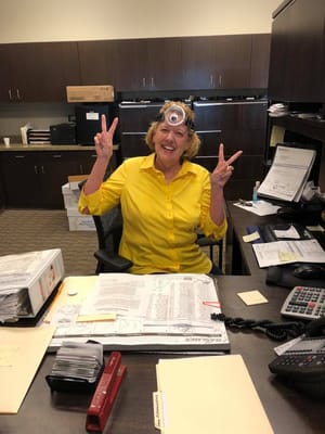 Staff member with a playful expression at her desk