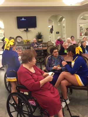 Residents engaging with cheerleaders in a common area