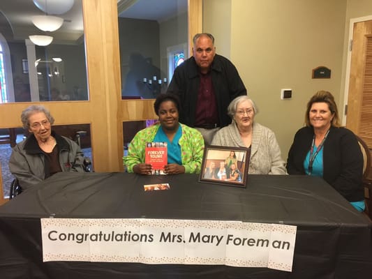 Residents and staff celebrating a milestone at a table