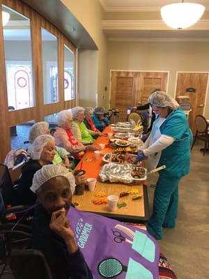 Residents and staff preparing a meal together