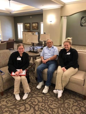 Residents and staff interacting in a cozy sitting area.