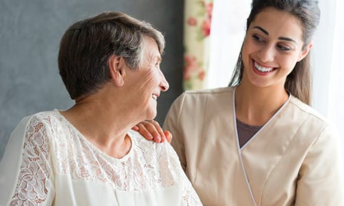 A caregiver smiling and interacting with a resident