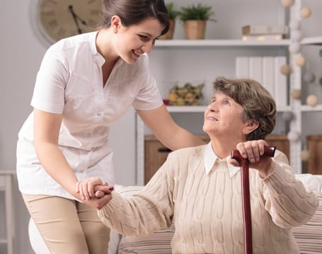Staff member assisting a resident in a cozy room