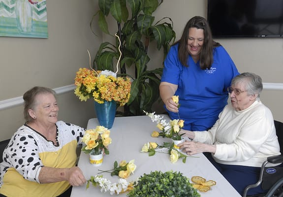 Residents participating in a flower arranging activity.