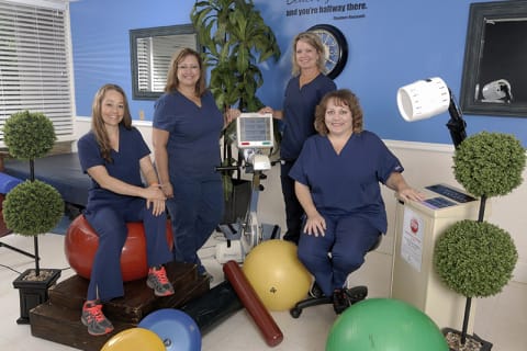 Staff members in a therapy room with equipment