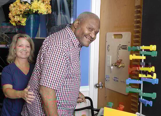 Staff assisting a resident in a cheerful interior setting