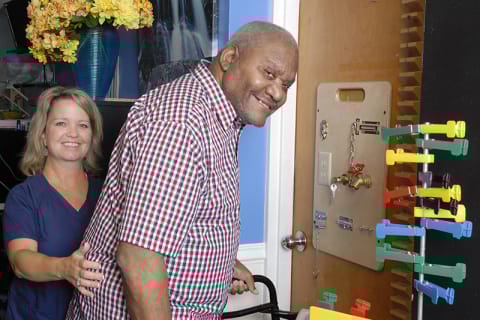 Staff assisting a resident in a colorful room