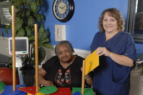 Therapist assisting a resident with activity.