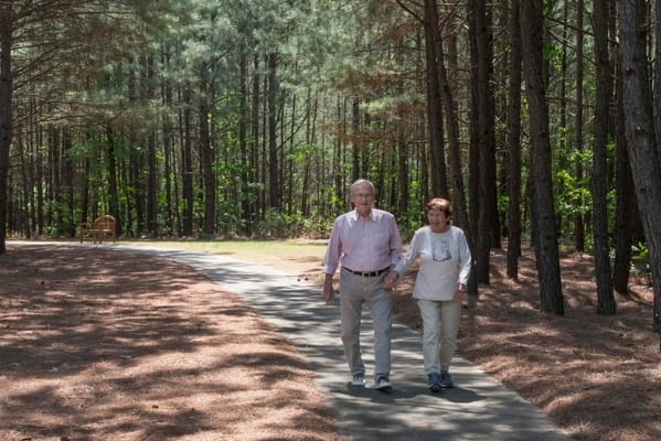 Couple walking along a path in a wooded area