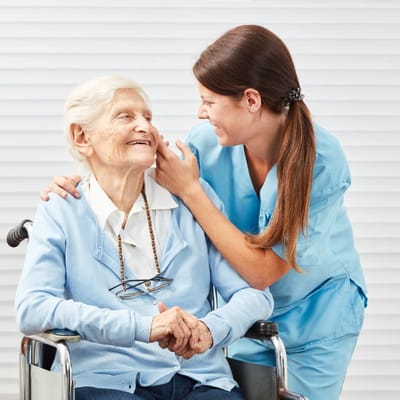 Resident smiling with a caregiver in a bright setting