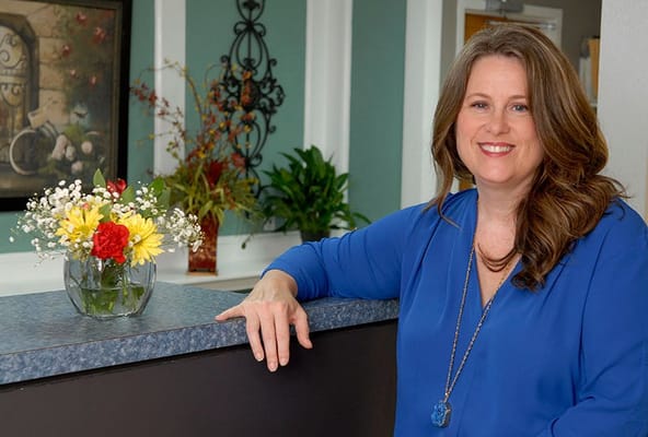 Staff member at reception desk with flowers