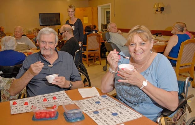 Residents enjoying bingo and snacks in a communal activity space
